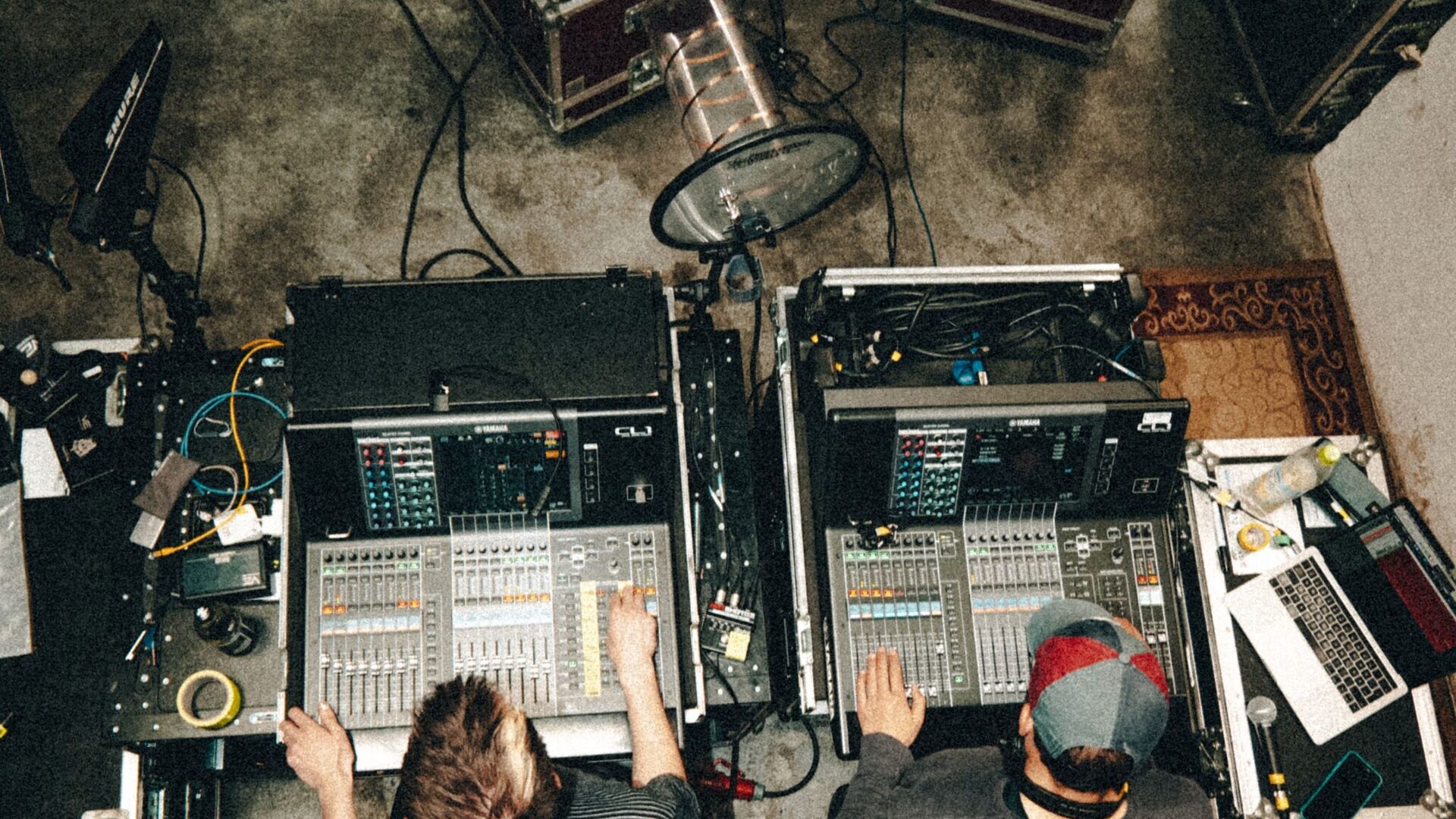 2 Sound Engineers photgraphed from the side looking at a mixing desk